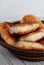 Potato pies on a ceramic dish opposite light background