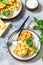 Potato waffles with peas, paprika, cheese and herbs, a quick snack in a plate on a gray stone countertop.