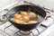 Potatoes boiling in a saucepan on a gas hob
