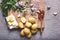 Potatoes, butter, wooden spoon with tomato sauce, garlic, spices and parsley on wooden cutting board