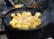 The potatoes are fried in a large saj frying pan outdoors. Family picnic dish