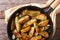 Potatoes fried in a pan, horizontal top view closeup, rustic