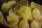 Potatoes fried wavy, embossed, potato chips with sour cream and greens, facies on a wooden board