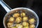 Potatoes in a peel are cooked in a pan. Cropped frame. Close-up