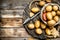 Potatoes in the sack on the tray with potato peeler