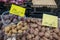 Potatoes sell on plastic boxes and shelf outside in front of grocery store