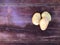 Potatoes unpeeled white-pink against a brown-red old shabby table, isolated