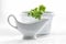 Potted parsley and a white gravy boat on a white background in high key