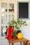 Potted plants,  boots and watering can on wooden table near house. Gardening tools