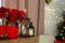 Potted poinsettias, burning candles and festive decor on dresser in room, space for text. Christmas traditional flower