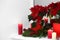 Potted poinsettias, burning candles and festive decor on windowsill in room, space for text. Christmas traditional flower