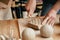 Potter cuts piece of clay with knife to soften it.