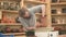 Potter forms an earthenware jug in his workshop. A bearded man works with clay