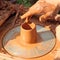 Potter hand taken closeup on pottery wheel.