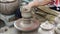 Potter hands making in clay on pottery wheel