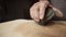 Potter with his strong hand crushes and squeezes piece of clay on table in workshop, closeup. Mans hand squeezes and