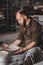 Potter making a plate of white clay on the potter`s wheel circle in studio, concept of creativity and art, vertical photo, top