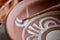 A potter paints a clay plate in a white in the workshop, top view, close-up, selective focus.