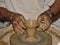 Potter`s craft. Hands of the potter make a vase on a potter`s wheel, close up