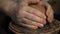 Potter`s hands shaping up the terracotta clay pot on wheal.