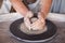 Potter`s wheel with clay. Women`s hands make a vase of clay