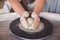 Potter`s wheel with clay. Women`s hands make a vase of clay