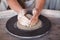 Potter`s wheel with clay. Women`s hands make a vase of clay