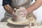 Potter sculpts from clay in a workshop of pots