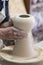 Potter sculpts from clay in a workshop of pots