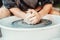 Potter wheel and potter hands, skilled hands of potter shaping the clay.