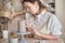 Potter woman in apron making a ceramic vase in a pottery workshop.