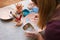 Potter woman paints a ceramic plate. Girl draws with a brush on earthenware. Process of creating clay products