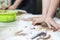 Pottering Concepts. Closeup of Hands of Female Worker Rolling a Piece of Wet Clay on Table Before Moulding