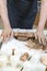 Pottering Concepts. Closeup of Hands of Male Worker Rolling a Piece of Wet Clay on Table Before Moulding