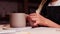 Pottery in the art studio - woman potter puts a piece of clay on the joint between the handle and cup