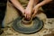 Pottery classes, student making clay pot on wheel. Close-up of dirty hands, sculpting clay crockery pottery training