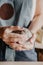 Pottery, clay, ceramics art concept - closeup on hands of young master with the large pieces of fireclay