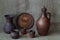 Pottery: clay jug for wine, dish, cups, pot and vase on rough homemade jute canvas. Concept â€” kitchen utensils, rustic style,