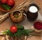 A pottery of cooked vegetables, a crock of milk, a wooden board with a tomato, cucumbers, bread and greens on a wooden surface