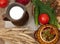 A pottery of cooked vegetables, a crock of milk, a wooden board with a tomato, cucumbers, bread and greens on a wooden surface