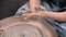 Pottery girl works with clay on a potter`s wheel. Handicraft production. Close-up.