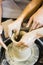 Pottery making. Smeared in clay hands of man and woman on potter`s wheel