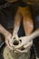 Pottery making. Smeared in clay hands of man and woman on potter`s wheel