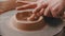 Pottery - master with finger is making the bottom for a clay bowl