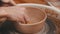 Pottery - master is wiping the bottom of the bowl with a yellow sponge