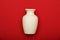 Pottery, vase, white clay jug isolated on red background. Pottery mockup made from white clay on a red background.