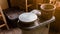 Pottery Wheel Machine for making hand crafted Ceramic such as bowls, plates and cups in foreground with wooden cask.