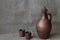 Pottery, wine set: clay jar and cups on a rough jute homespun cloth. Concept â€” kitchen utensils, rustic style, pottery. Minimal
