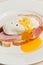 pouched egg, peppered, with yolk running out, onto a slice of ham, on white toast