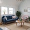 Pouf on blue carpet in bright living room interior with grey chair and settee against the wall with gallery